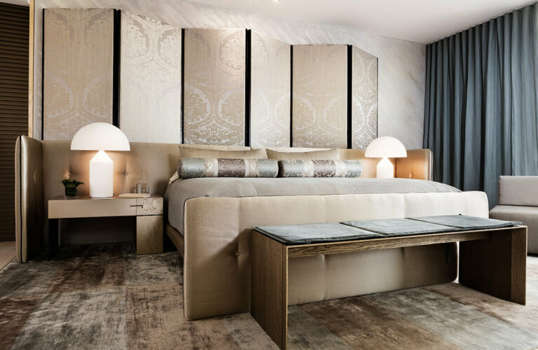 Luxurious bedroom with Antwerp Screen, large upholstered bed, modern lamps, and bench