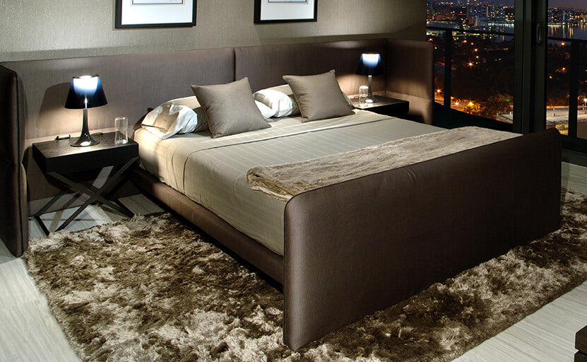 Modern bedroom with Como Bed featuring dark brown upholstered frame and light bedding