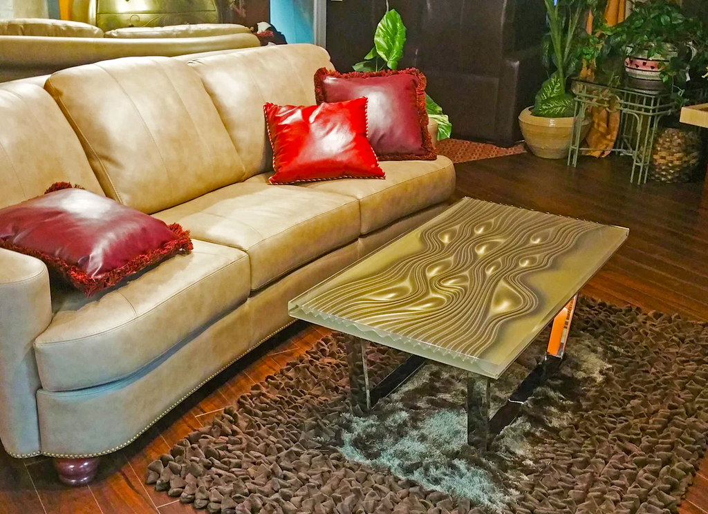 Light brown leather sofa with red pillows next to Phebus Bubbles Coffee Table