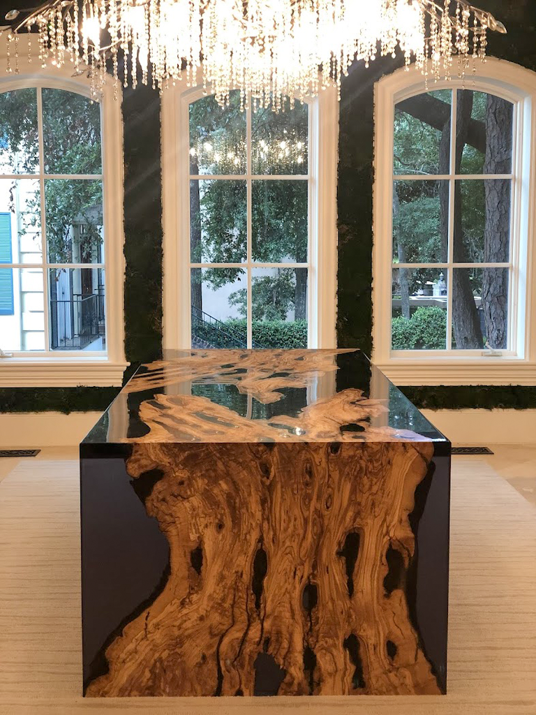 Olive wood dining table with clear resin top and large wooden tree trunk base
