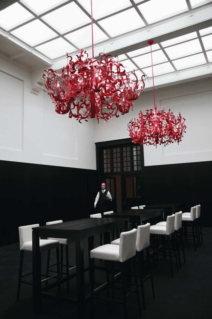 Ornate red flower power chandelier hanging from skylight ceiling in Flower Power Chandelier Round