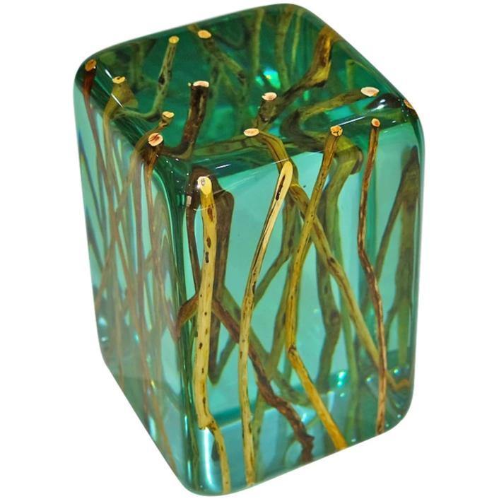 Green branches end table featuring a clear teal resin block encasing natural root-like structures