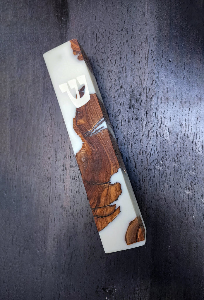 Modern mezuzah case made of light-colored resin with embedded dark reddish-brown wood