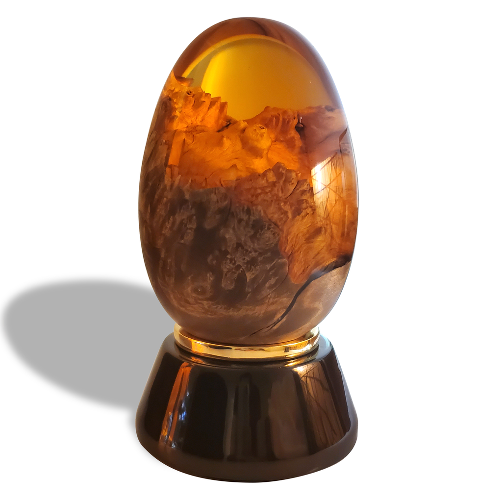 Orange Dragon Egg decorative piece with amber and wood on a dark glossy base with gold band