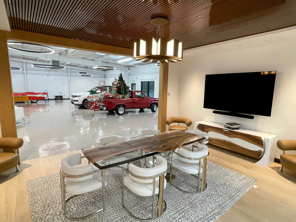 Spacious modern dining room with signature walnut dining table, large TV, and garage with classic cars and Christmas tree