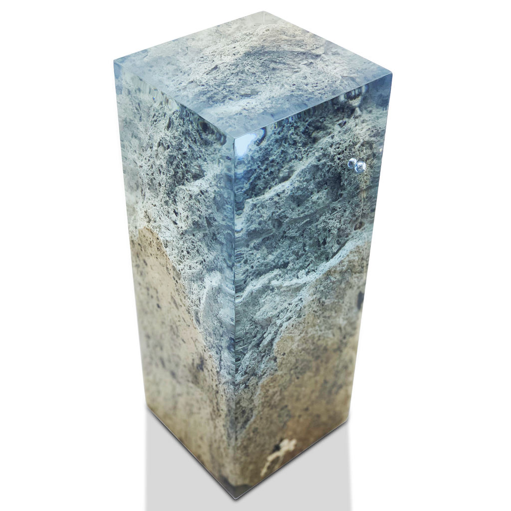 Clear resin encasing a textured travertine rock landscape in a travertine rock decorative cube